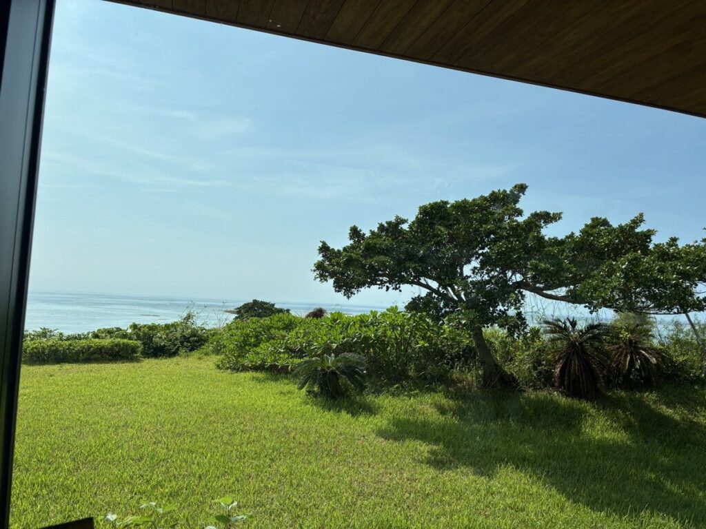 バンタカフェ「ごろごろラウンジ」の窓から見える芝生と海