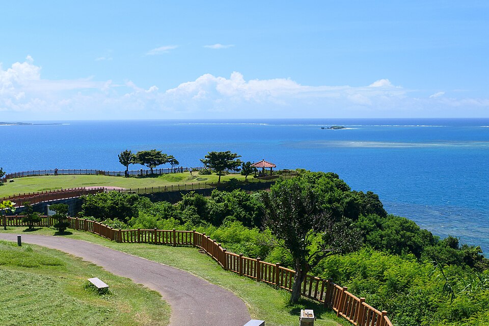 青い海を見渡す知念岬公園の遊歩道と東屋