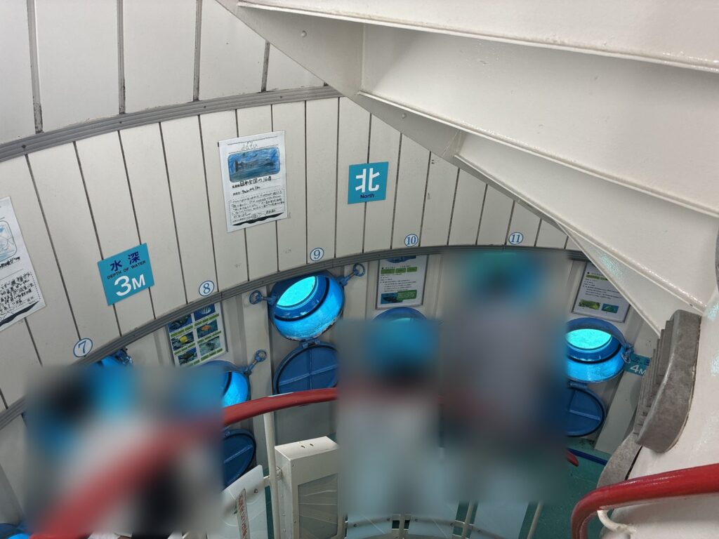 海中展望塔のらせん階段と、丸い窓が並ぶ塔の中(人物はぼかしています)